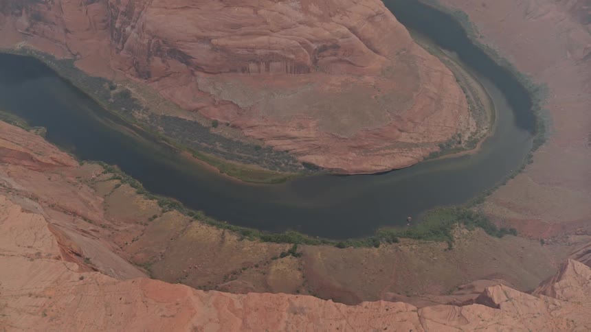 A river loops around red rock in a canyon