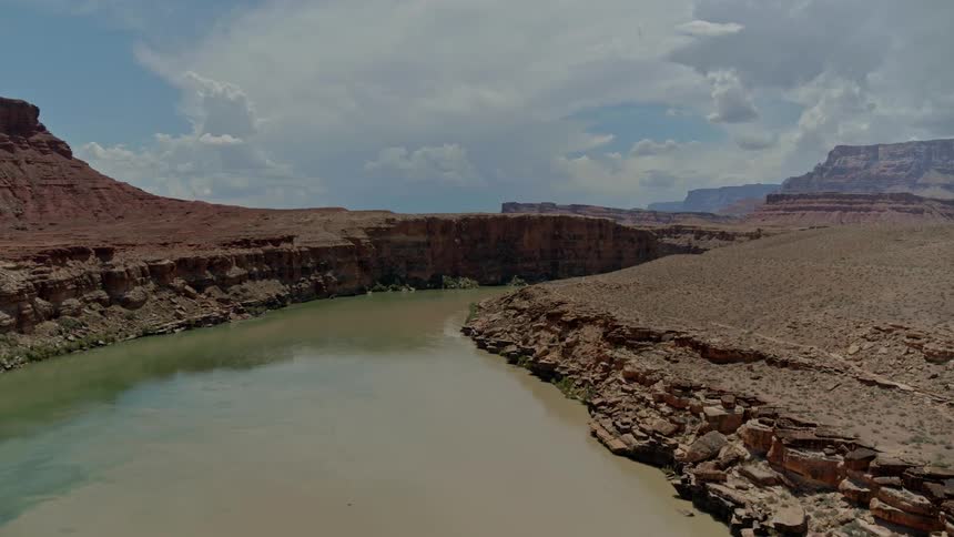 The river runs towards the mountains in the distance