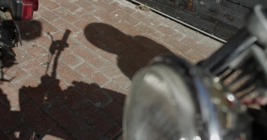 Shadow of a person putting on a motorcycle helmet