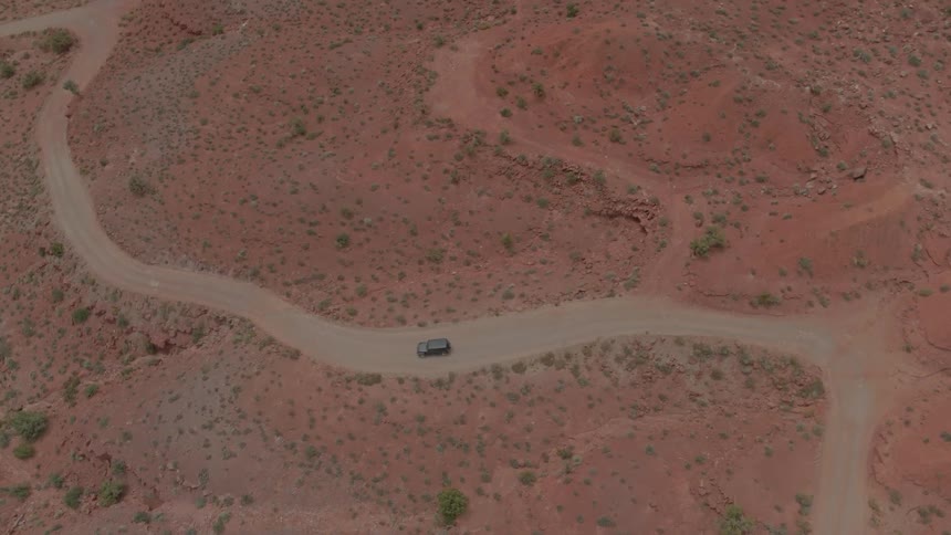 A car driving on a road in the desert