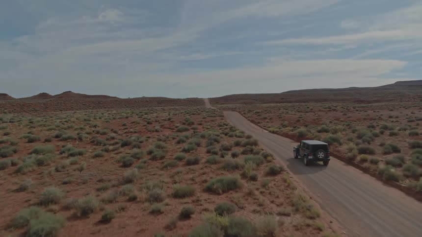 A jeep driving down a desert road