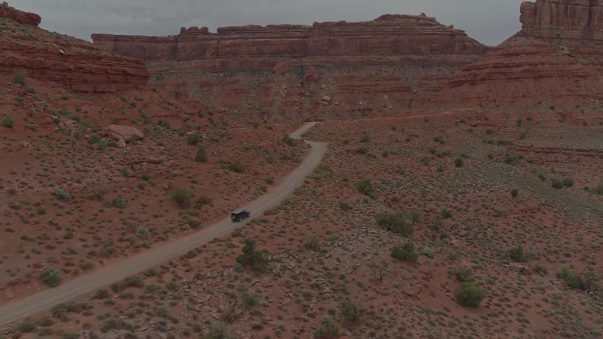 Car driving on dirt road through the desert