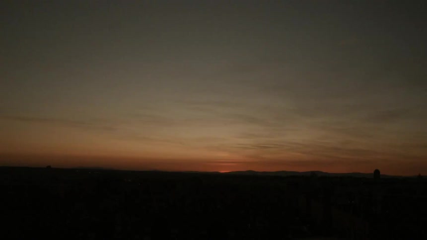 The sun sets over the horizon on a ranch