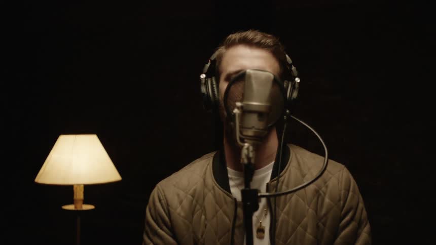 Man puts on headphones then speaks into microphone