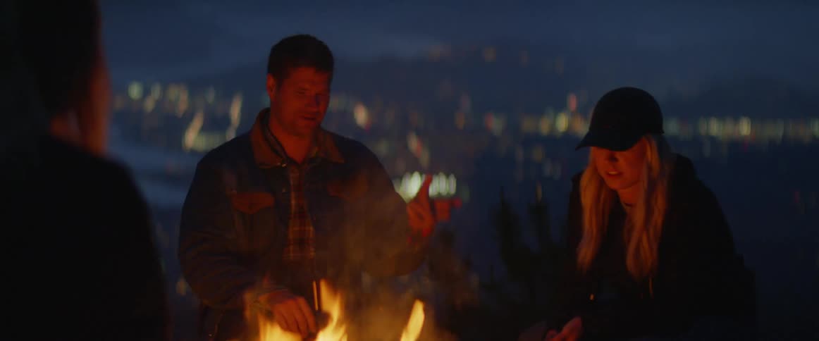 People gather around a campfire at dawn
