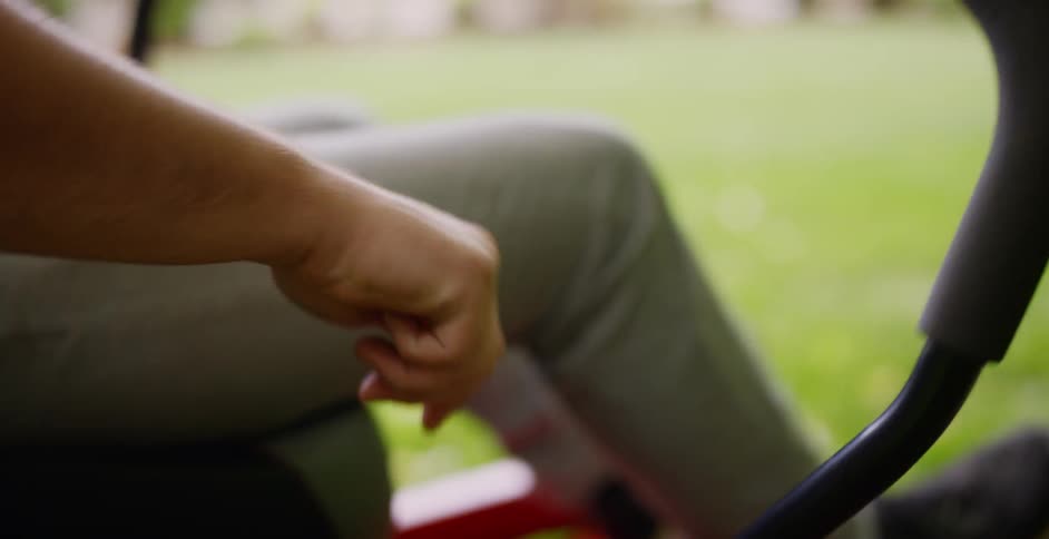 A person is turning on a lawn mower