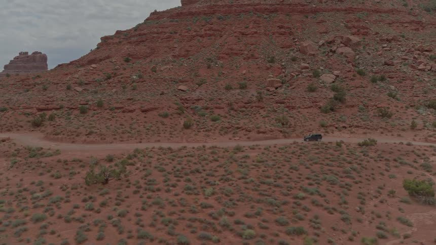 A land rover drives through a road in the desert