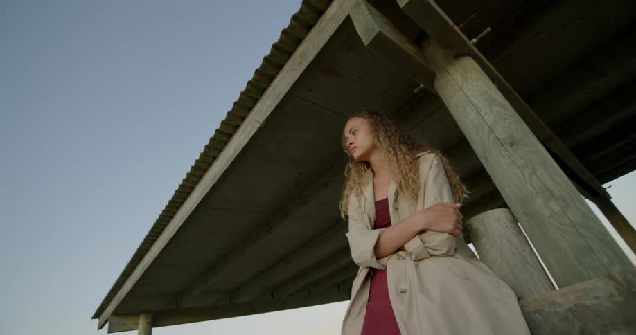A woman is sitting on a ledge outside