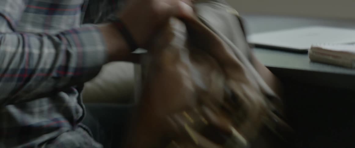 A person is closing his laptop and putting it in a bag