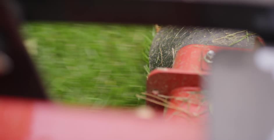 A riding lawnmower going quickly through a yard as seen from the tire