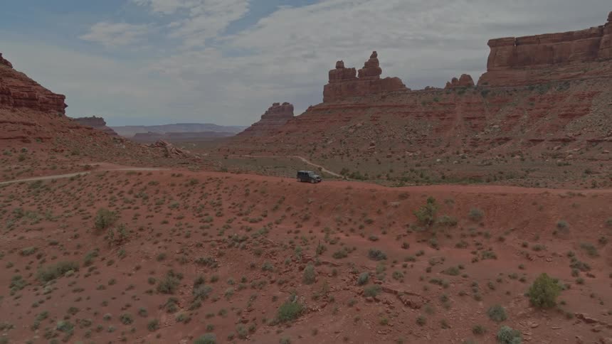 A vehicle parks on a hill in the desert