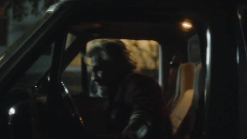 A man sits in the car at night