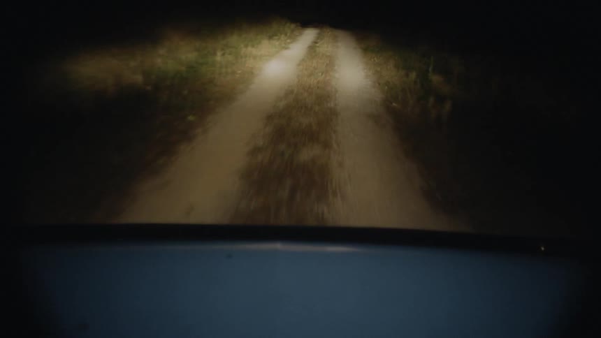 Truck Driving down rural road at night