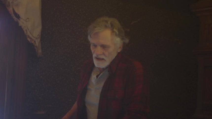 A man stumbles around in the dark room