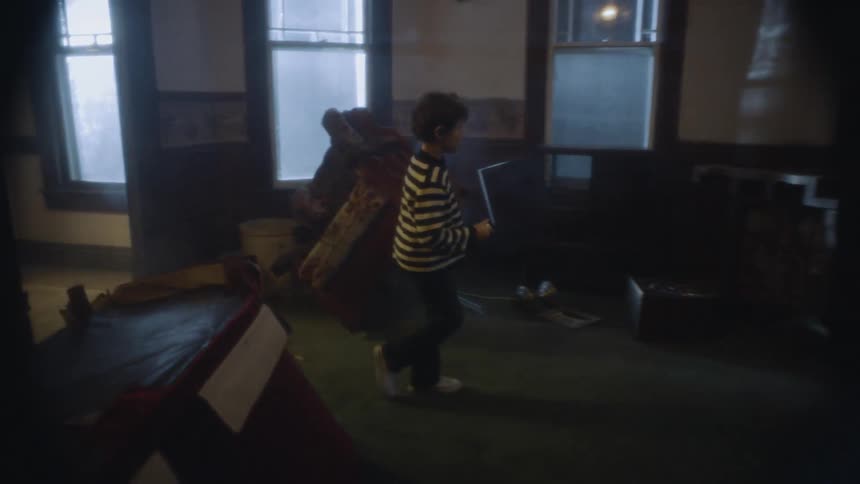 A young child walking around a dark room with a flashlight