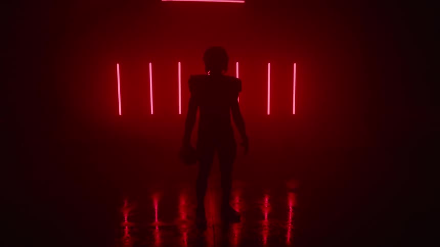 A person is standing in a room in the dark with a red light