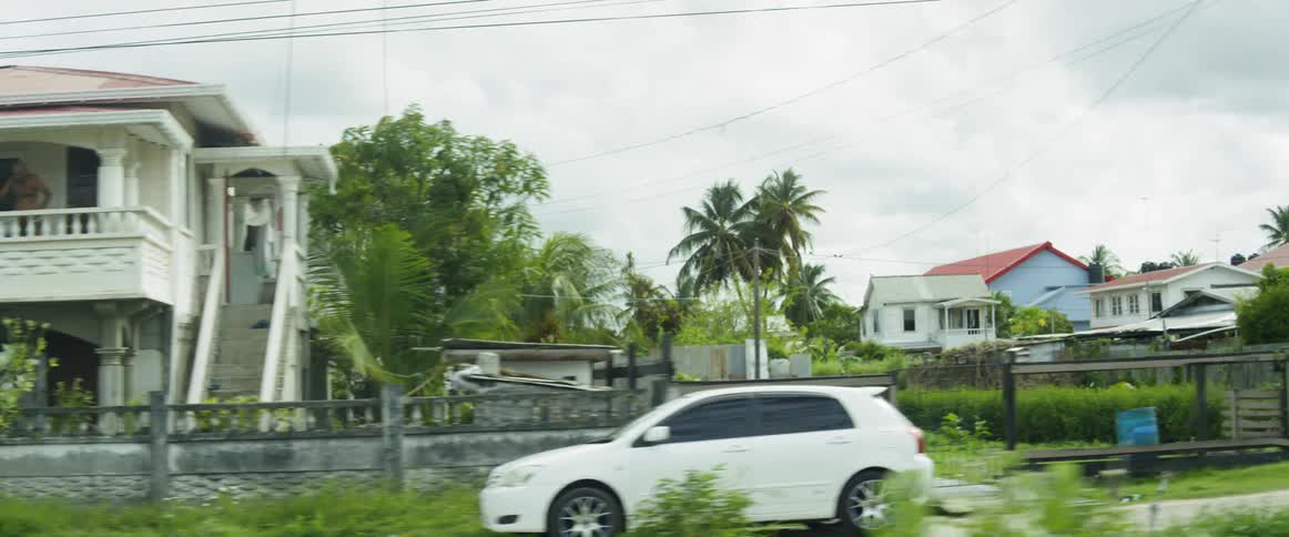 Cars are parked on the street by houses
