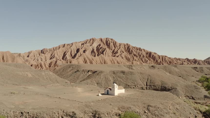 A white church stands on rural hills