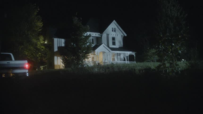 Truck pulling up to old house at night