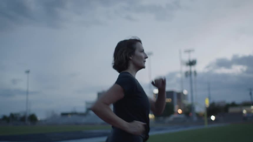 A woman is walking fast on the track