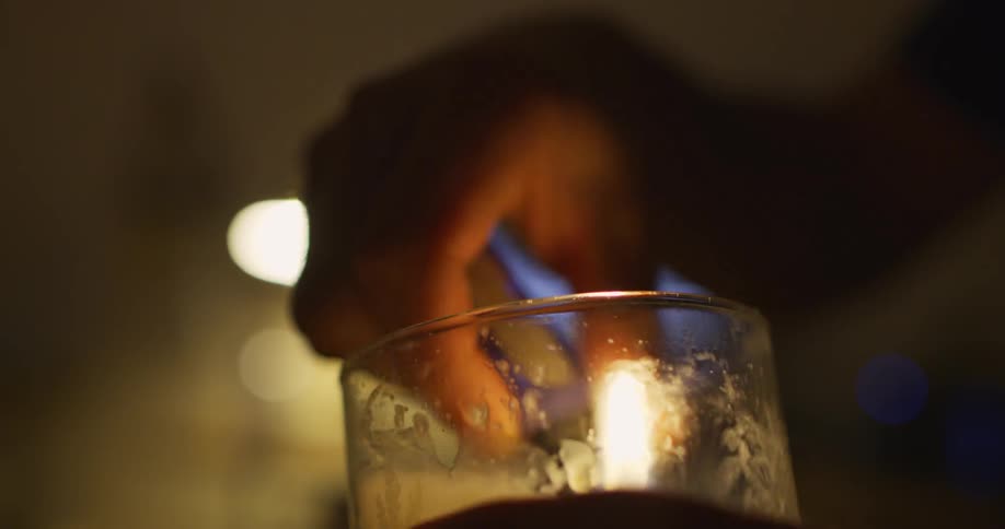 A man using a lighter to light a candle