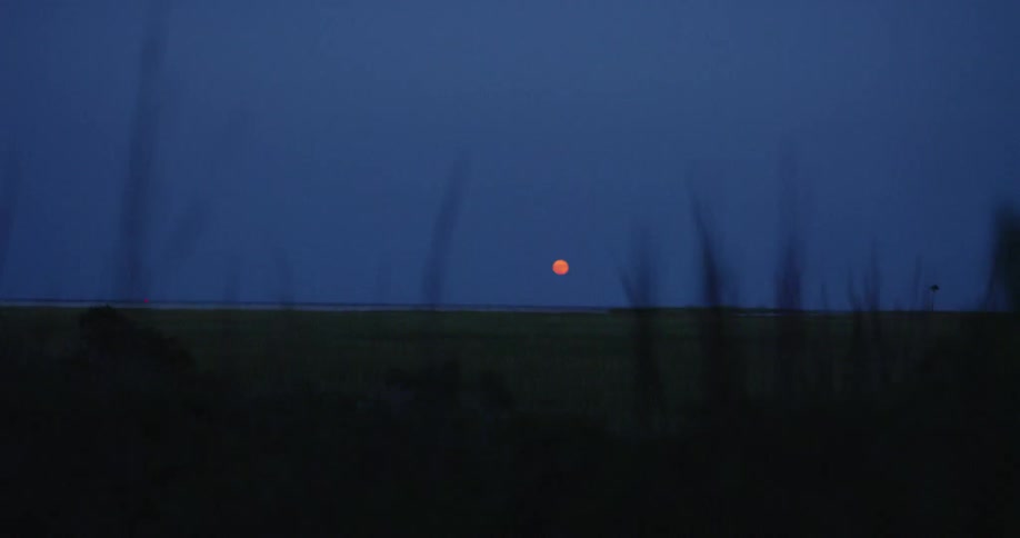 A red glowing moon in the distance