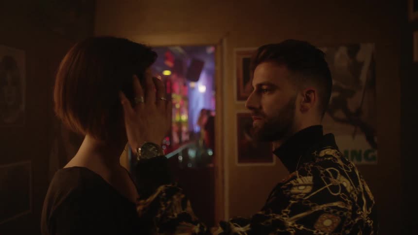 A woman applies makeup to a mans face until the man kisses her and is led away
