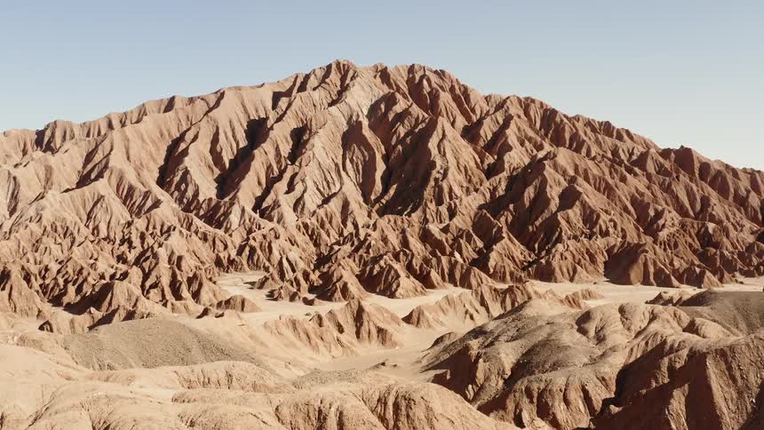 Sand covered hills lead to a small mountain