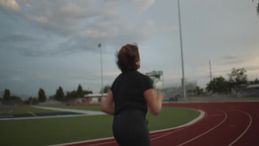 A woman jogging on a field track