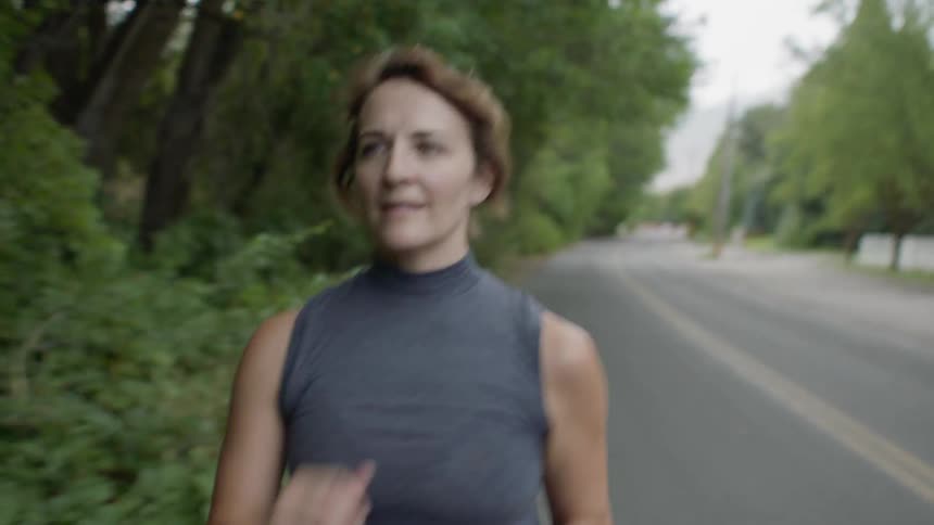 A woman is fast walking outdoors