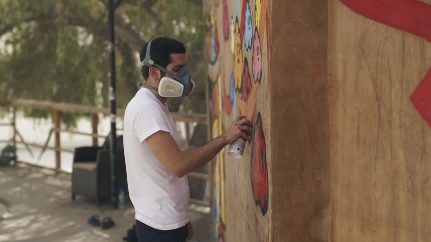 A man is spray painting the building