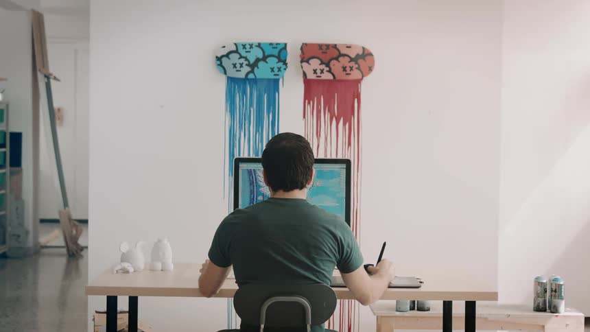 A man in his living room digitally drawing on his computer