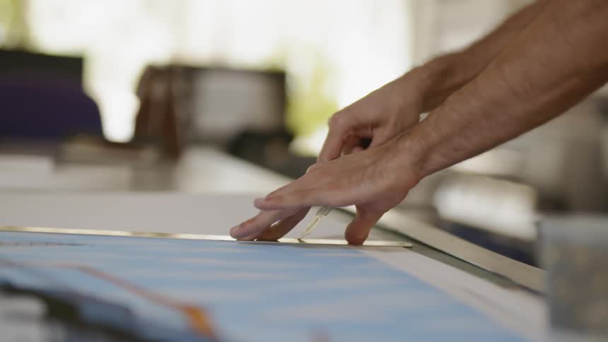 Man carefully cuts something with the help of a ruler