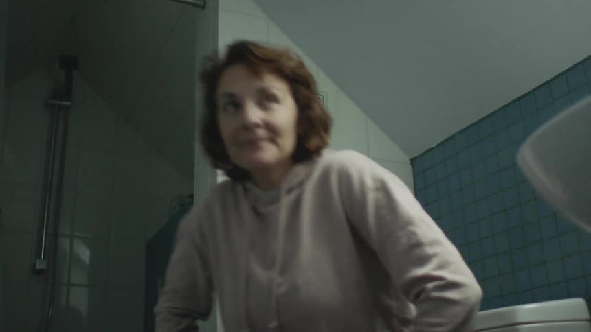 A woman stands up in the bathroom