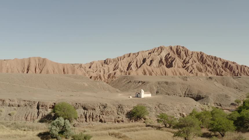 A small building sits by the mountain range