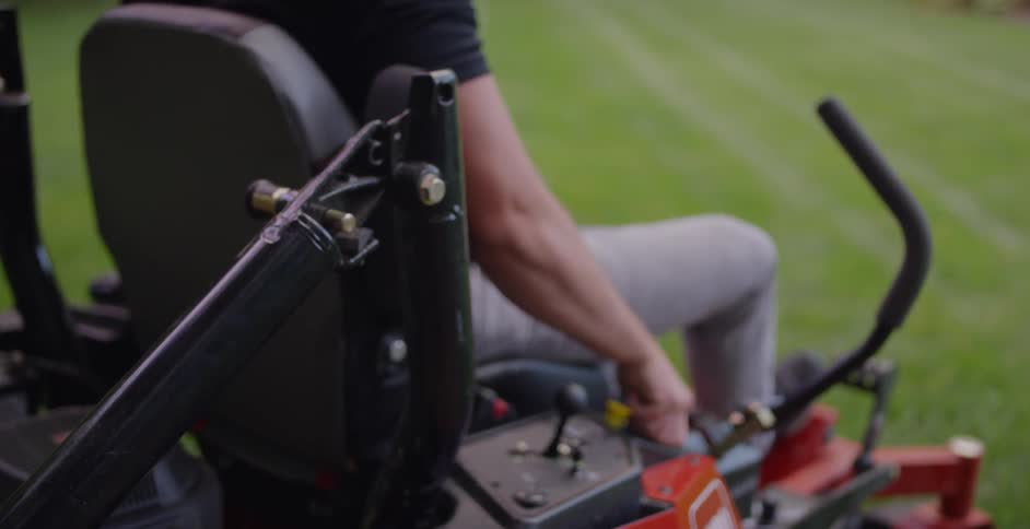 A man gets in a riding lawn mower