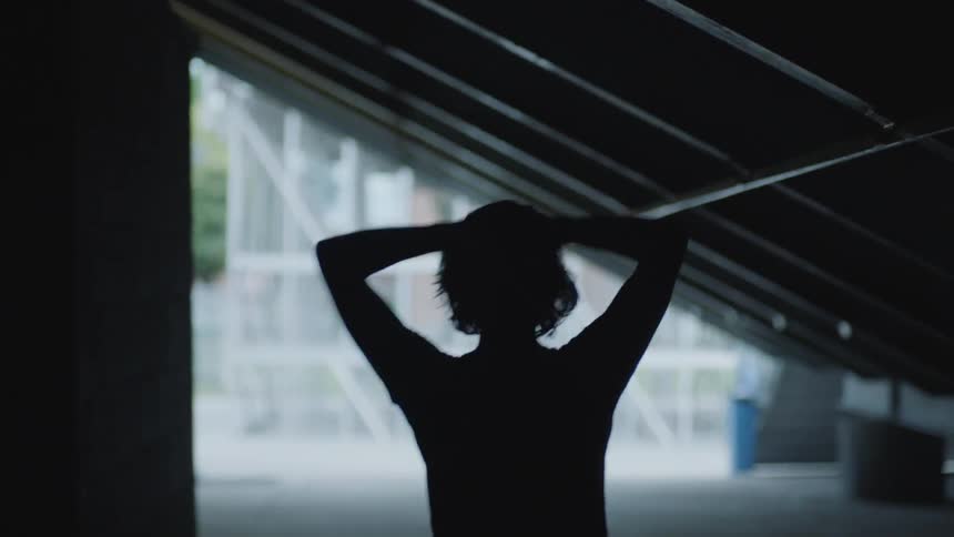 A person puts their hands on their head while walking