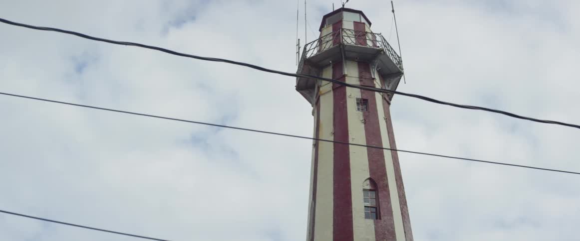 The tall tower is behind the power lines