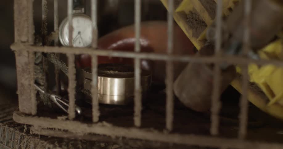 A watch and a compass sit in an old crate