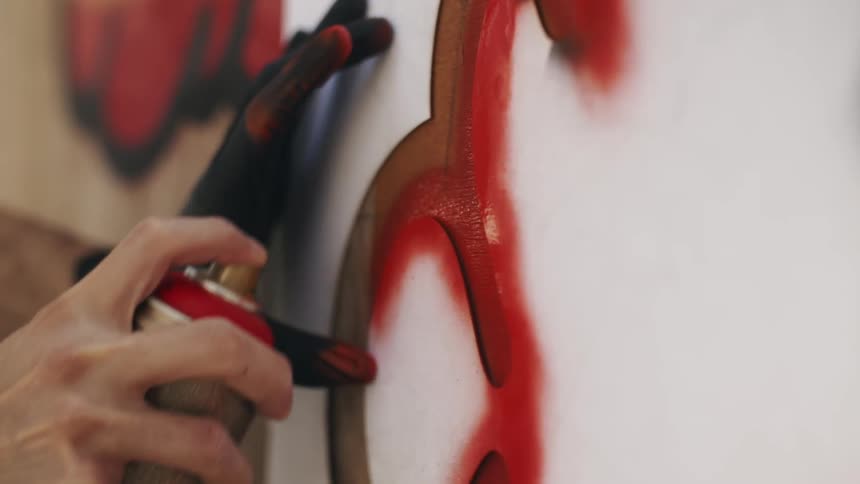 A person is spray painting a wall