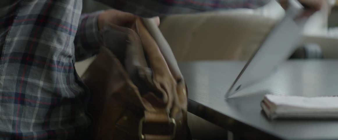 A man puts his laptop in his bag
