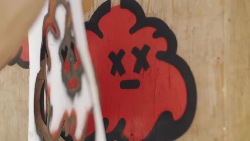 A person peels a label away from the graffiti