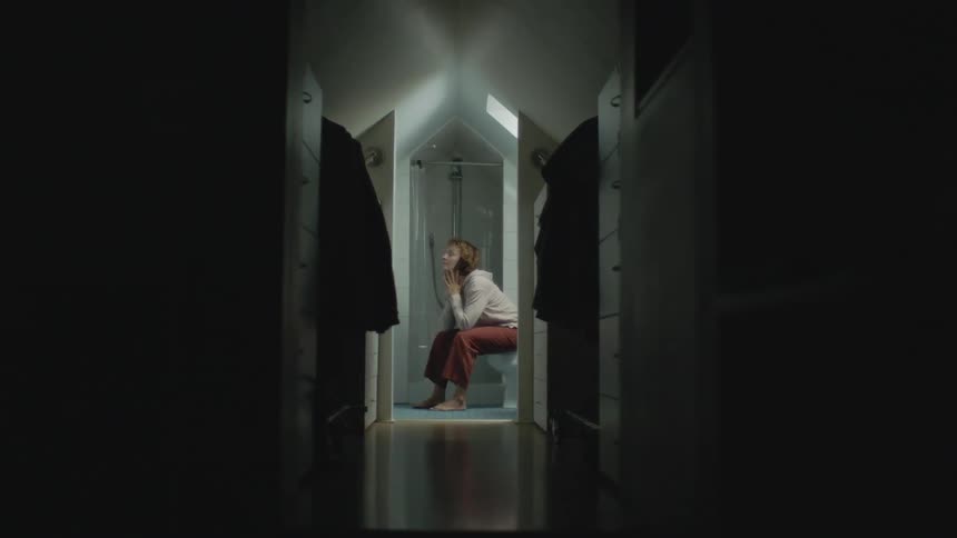 A woman sits in the bathroom