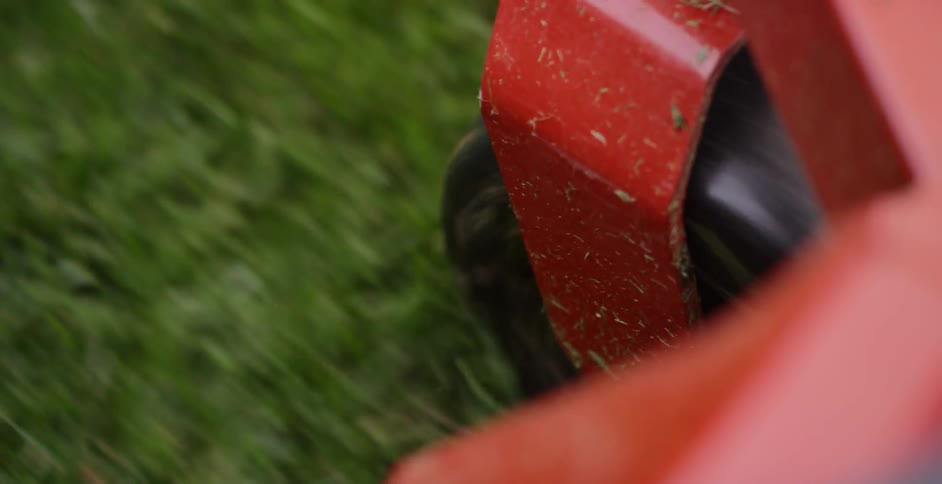 A wheel turns as green grass is rolled