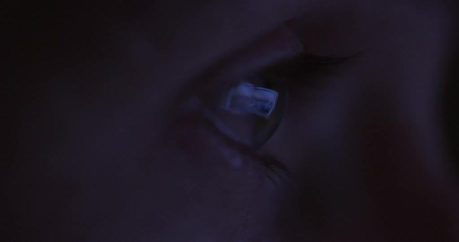 A person looks at a monitor in the dark