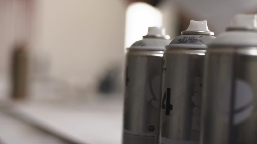 A couple cans of spray paint on a table