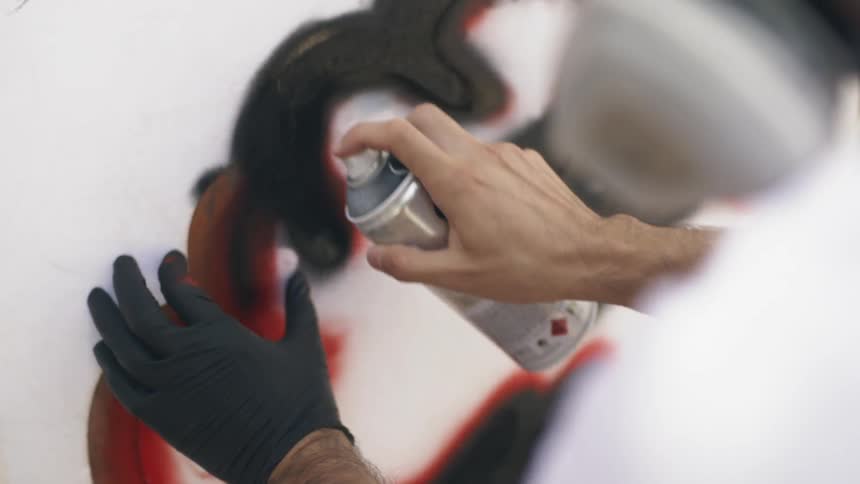 A person is spray painting a wall