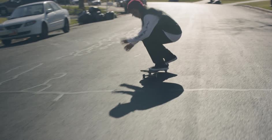A person riding a skateboard down a suburban street