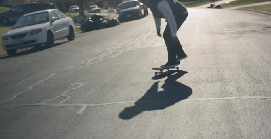 A man skateboarding on a suburban street