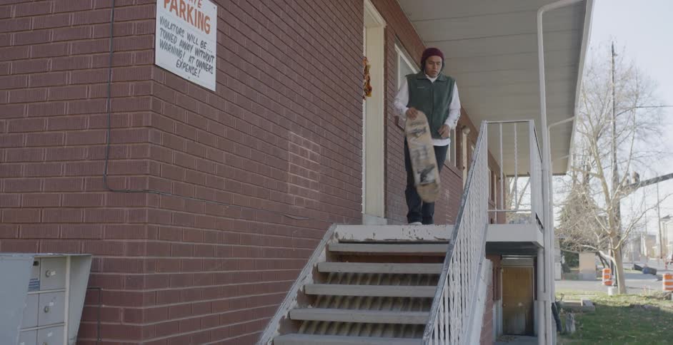 Man with skateboard looks like he wants to skateboard down steps